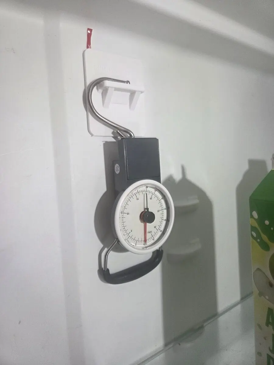 Hanging scale applying a proof load to an installed Fridge Bridge Support Bracket inside a refrigerator